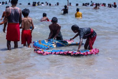 Kulashekharapatnam, Tamilnadu, Hindistan - 12 Ekim 2024: Kulasai Dasara, bir grup çocuk ve ebeveynleri kulasai dasara festivalinde deniz dalgalarının keyfini çıkarıyorlar.