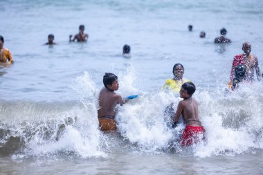 Kulashekharapatnam, Tamilnadu, Hindistan - 12 Ekim 2024: Kulasai Dasara, bir grup çocuk ve ebeveynleri kulasai dasara festivalinde deniz dalgalarının keyfini çıkarıyorlar.