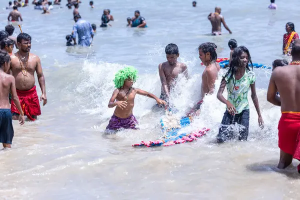 Kulashekharapatnam, Tamilnadu, Hindistan - 12 Ekim 2024: Kulasai Dasara, bir grup çocuk ve ebeveynleri kulasai dasara festivalinde deniz dalgalarının keyfini çıkarıyorlar.