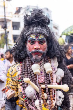 Varanasi, Uttar Pradesh, Hindistan - 20 Mart 2024: Masan Holi, Masan Holi, Masan Holi, Harishchandra ghat 'taki masaan holi kutlamaları sırasında tanrıça Kali olarak resmedilen bir kadın ressamın portresi.