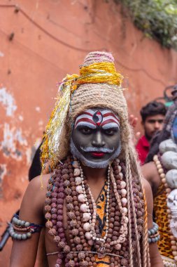 Varanasi, Uttar Pradesh, Hindistan - 20 Mart 2024: Masan Holi, Masan Holi, Masan Holi, Harishchandra ghat 'taki masaan holi kutlamaları sırasında tanrıça Kali olarak resmedilen bir kadın ressamın portresi.