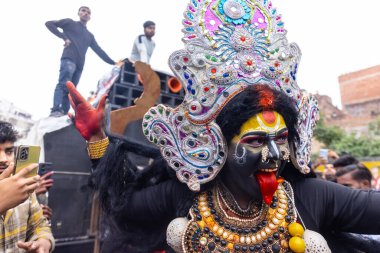Varanasi, Uttar Pradesh, Hindistan - 20 Mart 2024: Masan Holi, Masan Holi, Masan Holi, Harishchandra ghat 'taki masaan holi kutlamaları sırasında tanrıça Kali olarak resmedilen bir kadın ressamın portresi.