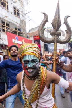 Varanasi, Uttar Pradesh, Hindistan - 20 Mart 2024: Masan Holi, Harishchandra ghat 'ta düzenlenen kutlama sırasında efendi shiva gibi giyinmiş kuru külle boyanmış bir erkek dindar portresi.