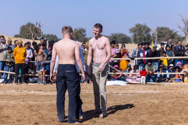 Bikaner, Rajasthan, Hindistan - 15 Ocak 2023: Bikaner festivali, Hint güreşçiler, bikaner festivali sırasında kum tabanında dostça bir maç olarak güreş veya kushti oynuyorlar.