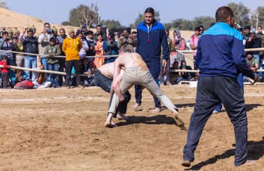 Bikaner, Rajasthan, Hindistan - 15 Ocak 2023: Bikaner festivali, Hint güreşçiler, bikaner festivali sırasında kum tabanında dostça bir maç olarak güreş veya kushti oynuyorlar.
