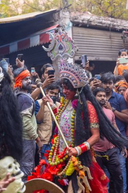 Varanasi, Uttar Pradesh, Hindistan - 20 Mart 2024: Masan Holi, Masan Holi, Masan Holi, Harishchandra ghat 'taki masaan holi kutlamaları sırasında tanrıça Kali olarak resmedilen bir kadın ressamın portresi.