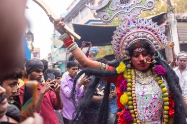 Varanasi, Uttar Pradesh, Hindistan - 20 Mart 2024: Masan Holi, Masan Holi, Masan Holi, Harishchandra ghat 'taki masaan holi kutlamaları sırasında tanrıça Kali olarak resmedilen bir kadın ressamın portresi.