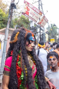 Varanasi, Uttar Pradesh, Hindistan - 20 Mart 2024: Masan Holi, Masan Holi, Masan Holi, Harishchandra ghat 'taki masaan holi kutlamaları sırasında tanrıça Kali olarak resmedilen bir kadın ressamın portresi.