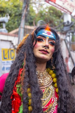 Varanasi, Uttar Pradesh, Hindistan - 20 Mart 2024: Masan Holi, Masan Holi, Masan Holi, Harishchandra ghat 'taki masaan holi kutlamaları sırasında tanrıça Kali olarak resmedilen bir kadın ressamın portresi.