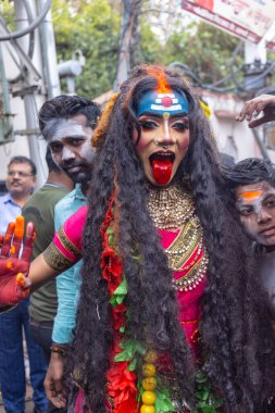 Varanasi, Uttar Pradesh, Hindistan - 20 Mart 2024: Masan Holi, Masan Holi, Masan Holi, Harishchandra ghat 'taki masaan holi kutlamaları sırasında tanrıça Kali olarak resmedilen bir kadın ressamın portresi.