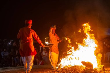 Bikaner, Rajasthan, Hindistan - 15 Ocak 2023: Bir grup din grubu Jasnathi Sampraday, Bikaner deve festivali sırasında yanan ormanın üzerinden yürüyerek açık alanda ateş dansı yaptı.