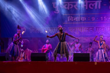 Puşkar, Rajasthan, Hindistan - 11 Kasım 2024: Folk dance, Afrika kıtasından bir grup erkek sanatçı geleneksel kabile kıyafetleriyle kültürel ateş dansı yapıyorlar.