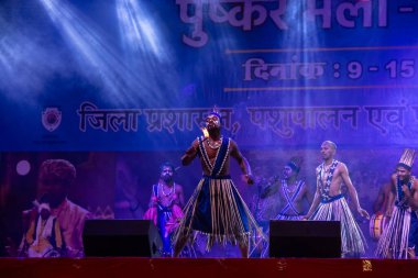 Puşkar, Rajasthan, Hindistan - 11 Kasım 2024: Folk dance, Afrika kıtasından bir grup erkek sanatçı geleneksel kabile kıyafetleriyle kültürel ateş dansı yapıyorlar.