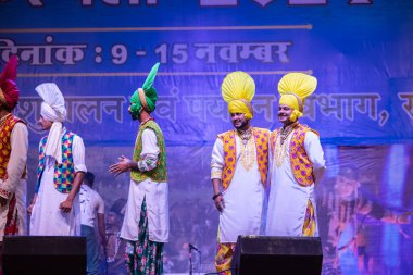 Puşkar, Rajasthan, Hindistan - 11 Kasım 2024: Folk dance, Afrika kıtasından bir grup erkek sanatçı geleneksel kabile kıyafetleriyle kültürel ateş dansı yapıyorlar.