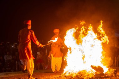 Puşkar, Rajasthan, Hindistan - 11 Kasım 2024: Folk dance, Afrika kıtasından bir grup erkek sanatçı geleneksel kabile kıyafetleriyle kültürel ateş dansı yapıyorlar.