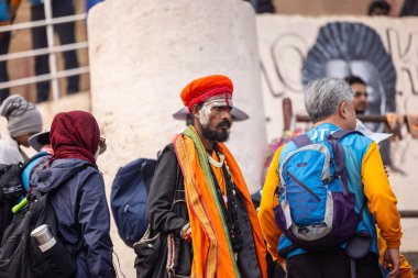 Varanasi, Uttar Pradesh, Hindistan - 20 Ocak 2024: Varanasi 'deki çetelerin yakınında dikilen geleneksel Hint turist portresi. Dünyanın dört bir yanındaki turistler moksha ve Yoga için Varanasi 'yi ziyaret ediyorlar..