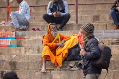 Varanasi, Uttar Pradesh, Hindistan - 20 Ocak 2024: Varanasi 'deki çetelerin yakınında dikilen geleneksel Hint turist portresi. Dünyanın dört bir yanındaki turistler moksha ve Yoga için Varanasi 'yi ziyaret ediyorlar..