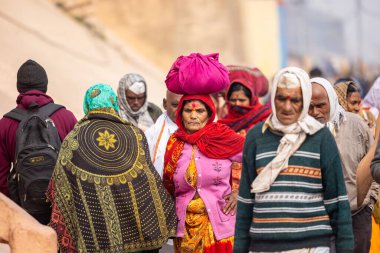 Varanasi, Uttar Pradesh, Hindistan - 20 Ocak 2024: Varanasi 'deki çetelerin yakınında dikilen geleneksel Hint turist portresi. Dünyanın dört bir yanındaki turistler moksha ve Yoga için Varanasi 'yi ziyaret ediyorlar.. 
