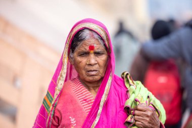 Varanasi, Uttar Pradesh, Hindistan - 20 Ocak 2024: Varanasi 'deki çetelerin yakınında dikilen geleneksel Hint turist portresi. Dünyanın dört bir yanındaki turistler moksha ve Yoga için Varanasi 'yi ziyaret ediyorlar..