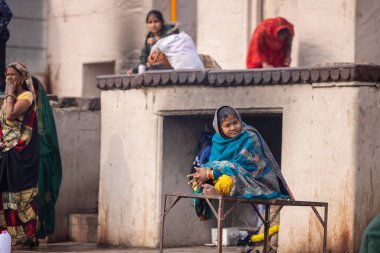 Varanasi, Uttar Pradesh, Hindistan - 20 Ocak 2024: Varanasi 'deki çetelerin yakınında dikilen geleneksel Hint turist portresi. Dünyanın dört bir yanındaki turistler moksha ve Yoga için Varanasi 'yi ziyaret ediyorlar.. 