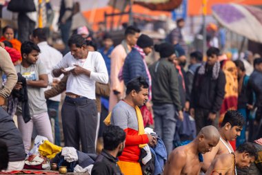 Varanasi, Uttar Pradesh, Hindistan - 20 Ocak 2024: Varanasi 'deki çetelerin yakınında dikilen geleneksel Hint turist portresi. Dünyanın dört bir yanındaki turistler moksha ve Yoga için Varanasi 'yi ziyaret ediyorlar.. 