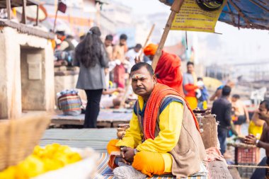Varanasi, Uttar Pradesh, Hindistan - 20 Ocak 2024: Varanasi 'deki çetelerin yakınında dikilen geleneksel Hint turist portresi. Dünyanın dört bir yanındaki turistler moksha ve Yoga için Varanasi 'yi ziyaret ediyorlar.. 