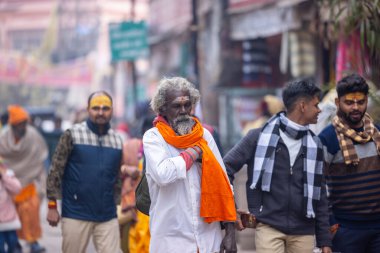 Varanasi, Uttar Pradesh, Hindistan - 20 Ocak 2024: Varanasi 'deki çetelerin yakınında dikilen geleneksel Hint turist portresi. Dünyanın dört bir yanındaki turistler moksha ve Yoga için Varanasi 'yi ziyaret ediyorlar.. 