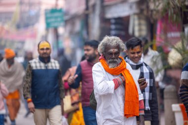 Varanasi, Uttar Pradesh, Hindistan - 20 Ocak 2024: Varanasi 'deki çetelerin yakınında dikilen geleneksel Hint turist portresi. Dünyanın dört bir yanındaki turistler moksha ve Yoga için Varanasi 'yi ziyaret ediyorlar.. 
