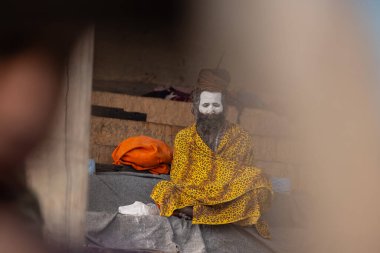 Varanasi, Uttar Pradesh, Hindistan - 20 Ocak 2024: Varanasi 'deki çetelerin yakınında dikilen geleneksel Hint turist portresi. Dünyanın dört bir yanındaki turistler moksha ve Yoga için Varanasi 'yi ziyaret ediyorlar.. 