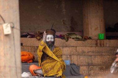 Varanasi, Uttar Pradesh, Hindistan - 20 Ocak 2024: Varanasi 'deki çetelerin yakınında dikilen geleneksel Hint turist portresi. Dünyanın dört bir yanındaki turistler moksha ve Yoga için Varanasi 'yi ziyaret ediyorlar.. 