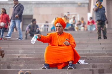 Varanasi, Uttar Pradesh, Hindistan - 20 Ocak 2024: Varanasi 'deki çetelerin yakınında dikilen geleneksel Hint turist portresi. Dünyanın dört bir yanındaki turistler moksha ve Yoga için Varanasi 'yi ziyaret ediyorlar..