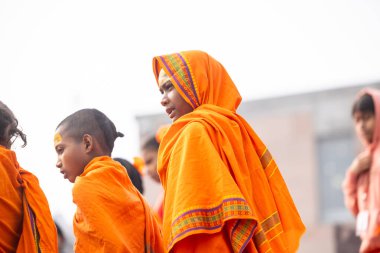 Varanasi, Uttar Pradesh, Hindistan - 20 Ocak 2024: Gurukul 'un ya da okulun kimliği belirsiz erkek öğrencileri kış sabahı Varanasi' de kutsal nehir keneviri yakınlarındaki ghat üzerinde oturuyorlar.