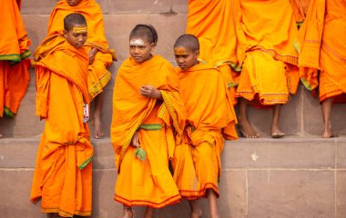 Varanasi, Uttar Pradesh, Hindistan - 20 Ocak 2024: Gurukul 'un ya da okulun kimliği belirsiz erkek öğrencileri kış sabahı Varanasi' de kutsal nehir keneviri yakınlarındaki ghat üzerinde oturuyorlar.