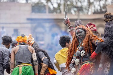 Varanasi, Uttar Pradesh, Hindistan - 20 Mart 2024: Masan Holi, Harishchandra ghat kutlamaları sırasında boyalı yüzlü dindarlar.