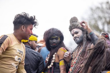Varanasi, Uttar Pradesh, Hindistan - 20 Mart 2024: Masan Holi, Harishchandra ghat kutlamaları sırasında boyalı yüzlü dindarlar.