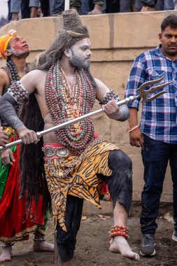 Varanasi, Uttar Pradesh, Hindistan - 20 Mart 2024: Masan Holi, Harishchandra ghat kutlamaları sırasında boyalı yüzlü dindarlar.