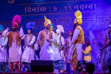 Puşkar, Rajasthan, Hindistan - 11 Kasım 2024: Bhangra, Bhangra grubu, açık hava kültür gecesi renkli etnik elbiseler içinde bhangra dansı yapıyor.
