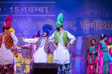 Puşkar, Rajasthan, Hindistan - 11 Kasım 2024: Bhangra, Bhangra Sanatçılar Grubu, renkli etnik elbiseler içinde dans ediyorlar..