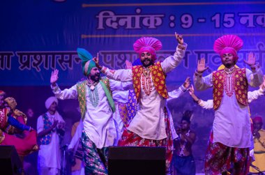 Puşkar, Rajasthan, Hindistan - 11 Kasım 2024: Bhangra, Bhangra Sanatçılar Grubu, renkli etnik elbiseler içinde dans ediyorlar..
