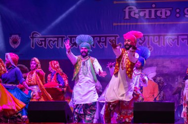 Puşkar, Rajasthan, Hindistan - 11 Kasım 2024: Bhangra, Bhangra Sanatçılar Grubu, renkli etnik elbiseler içinde dans ediyorlar..