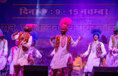 Puşkar, Rajasthan, Hindistan - 11 Kasım 2024: Bhangra, Bhangra Sanatçılar Grubu, renkli etnik elbiseler içinde dans ediyorlar..