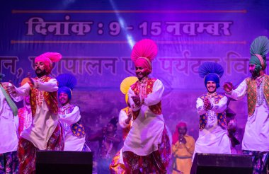 Puşkar, Rajasthan, Hindistan - 11 Kasım 2024: Bhangra, Bhangra Sanatçılar Grubu, renkli etnik elbiseler içinde dans ediyorlar..