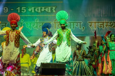 Puşkar, Rajasthan, Hindistan - 11 Kasım 2024: Bhangra, Bhangra Sanatçılar Grubu, renkli etnik elbiseler içinde dans ediyorlar..