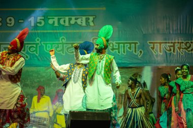 Puşkar, Rajasthan, Hindistan - 11 Kasım 2024: Bhangra, Bhangra Sanatçılar Grubu, renkli etnik elbiseler içinde dans ediyorlar..