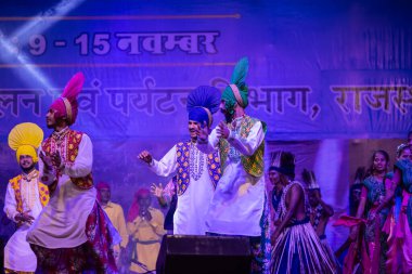 Puşkar, Rajasthan, Hindistan - 11 Kasım 2024: Bhangra, Bhangra Sanatçılar Grubu, renkli etnik elbiseler içinde dans ediyorlar..