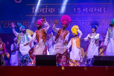 Puşkar, Rajasthan, Hindistan - 11 Kasım 2024: Bhangra, Bhangra Sanatçılar Grubu, renkli etnik elbiseler içinde dans ediyorlar..