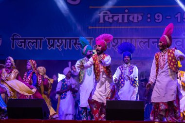 Puşkar, Rajasthan, Hindistan - 11 Kasım 2024: Bhangra, Bhangra Sanatçılar Grubu, renkli etnik elbiseler içinde dans ediyorlar..