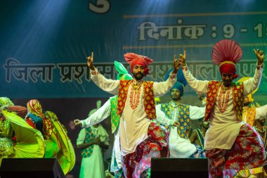 Puşkar, Rajasthan, Hindistan - 11 Kasım 2024: Bhangra, Bhangra Sanatçılar Grubu, renkli etnik elbiseler içinde dans ediyorlar..
