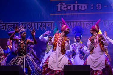 Puşkar, Rajasthan, Hindistan - 11 Kasım 2024: Bhangra, Bhangra Sanatçılar Grubu, renkli etnik elbiseler içinde dans ediyorlar..