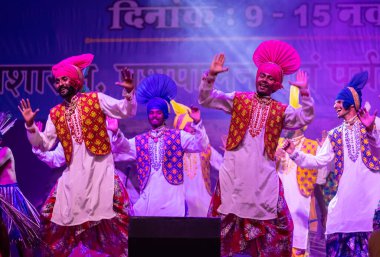Puşkar, Rajasthan, Hindistan - 11 Kasım 2024: Bhangra, Bhangra Sanatçılar Grubu, renkli etnik elbiseler içinde dans ediyorlar..